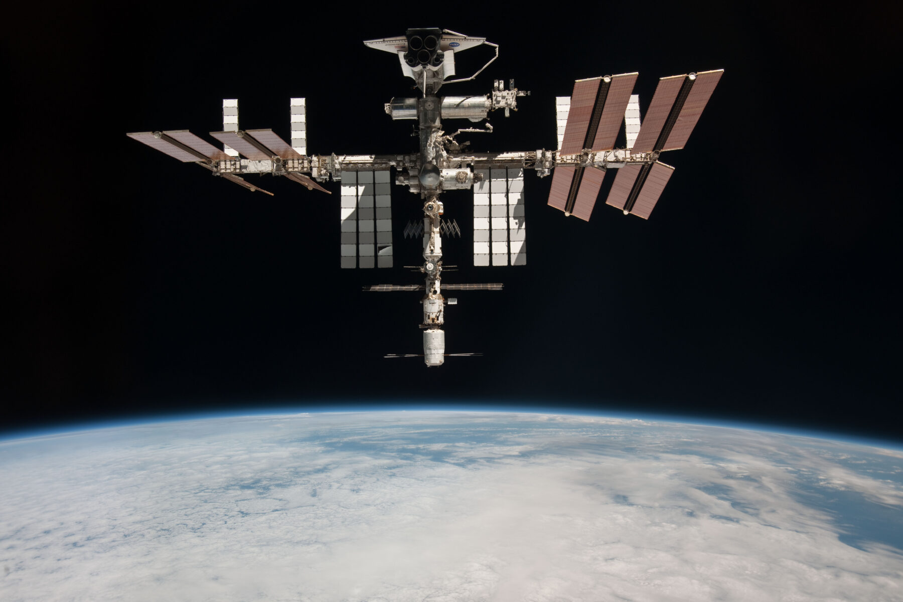 hoto de la station spatiale internationale prise en mai 2011 par l’astronaute italien Paolo Nespoli depuis une capsule russe Soyouz en route vers la Terre. En haut de l’image on aperçoit Endeavour pendant l’avant-dernière mission d’une navette spatiale : STS-134. Crédit : NASA
