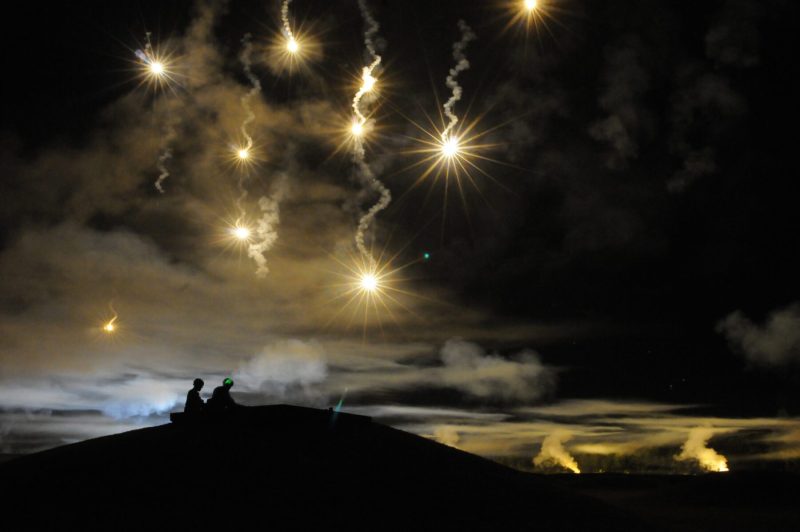 Participants in the Department of the Army Best Warrior Competition fire at targets as the night sky is illumintated with simulated munitions, adding a breath of realism to the night fire event.  The competition was held at Sept. 27-Oct. 2 at Fort Lee, Va. (photo by T. Anthony Bell)